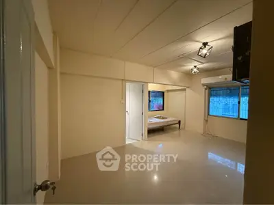 Spacious unfurnished room with tiled flooring and large window for natural light.