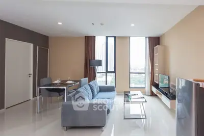 Modern living room with sleek furniture and large windows offering city views.