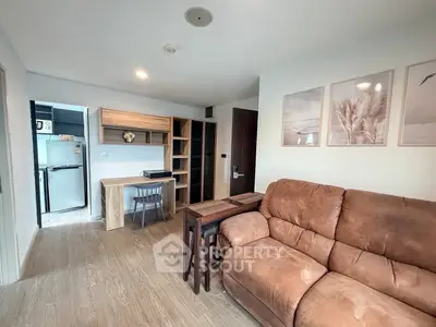 Cozy living room with modern decor and open layout, featuring a comfortable sofa and stylish wall art.