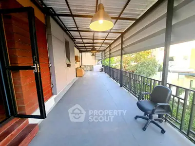 Spacious balcony with modern lighting and outdoor seating in a contemporary home