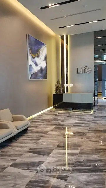 Luxurious modern building lobby with elegant marble flooring and contemporary art decor.