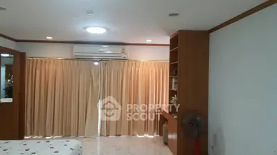Spacious bedroom with air conditioning and built-in shelves, perfect for comfort and organization.
