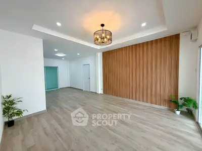 Spacious modern living room with elegant wood paneling and stylish lighting