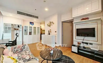 Modern living room with stylish decor and built-in storage, featuring a cozy seating area and wall-mounted TV.
