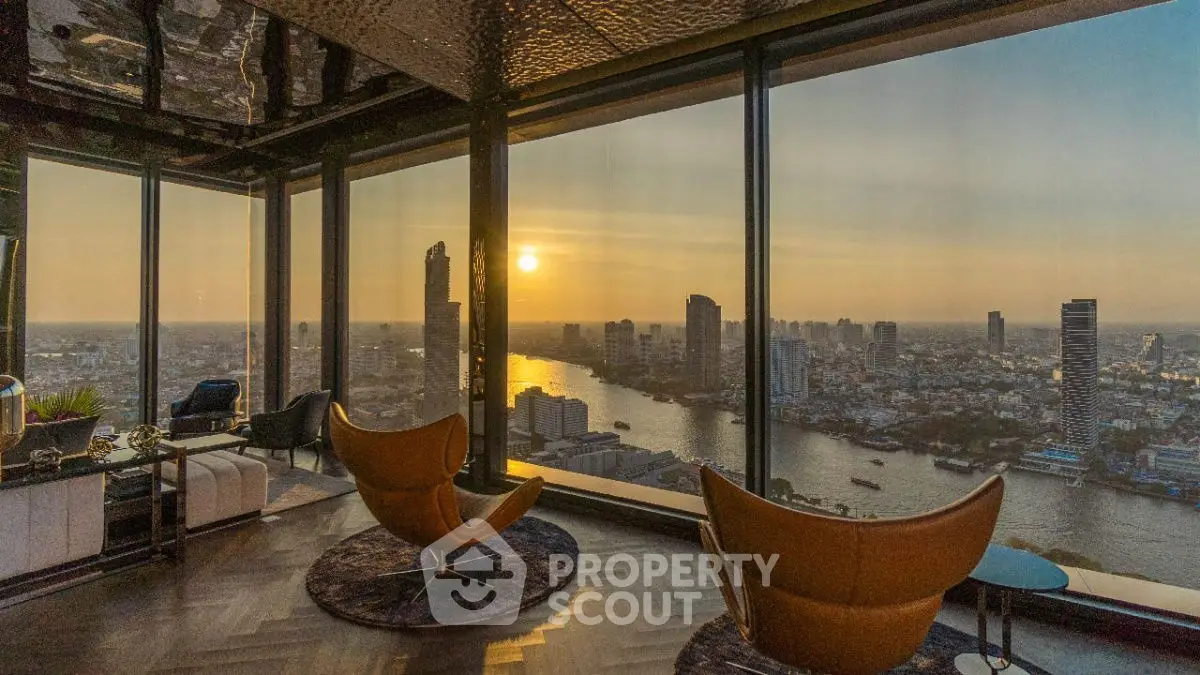 Luxurious high-rise living room with panoramic city and river views at sunset.