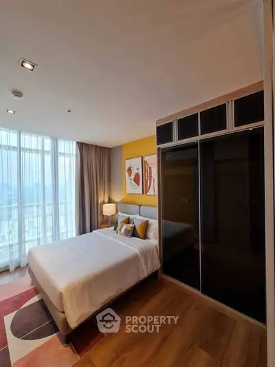 Modern bedroom with large window and stylish decor in a high-rise apartment.