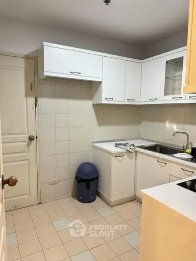 Charming kitchen with white cabinets and tiled backsplash, perfect for modern living.