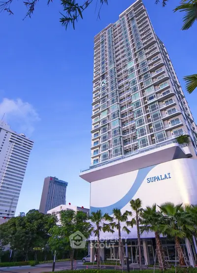 Stunning high-rise building with modern architecture and lush greenery in urban setting.