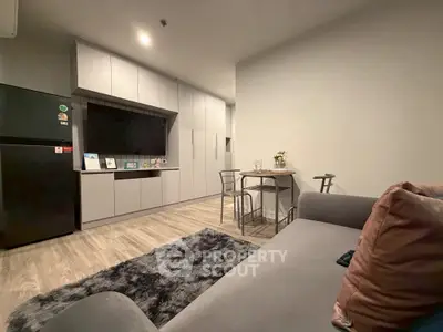 Modern open-layout kitchen and living area with sleek cabinetry and cozy seating.