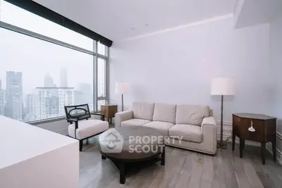 Modern living room with city view, featuring stylish furniture and large windows.