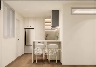 Modern kitchen with sleek design, featuring a breakfast bar and stylish lighting.