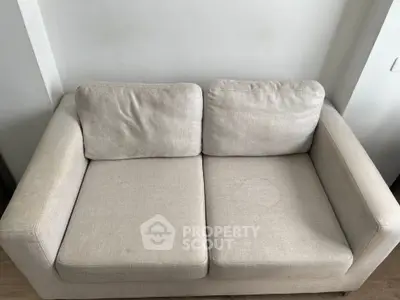 Cozy beige sofa in a modern living room setting, perfect for relaxation and comfort.