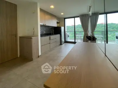 Modern kitchen with open layout and scenic balcony view in a stylish apartment.