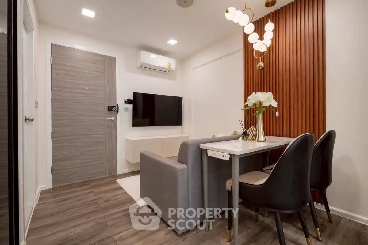 Modern living room with stylish decor and dining area, featuring a wall-mounted TV and elegant lighting.