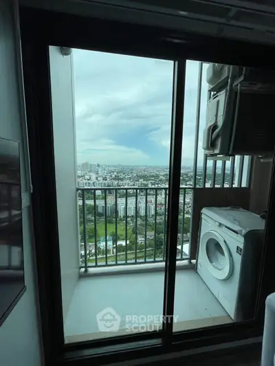 High-rise apartment balcony with stunning city view and washing machine.