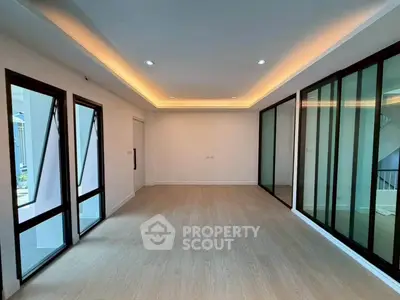 Spacious modern living room with floor-to-ceiling windows and elegant lighting