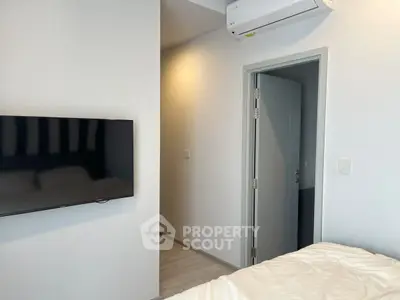 Modern bedroom with wall-mounted TV and air conditioning unit