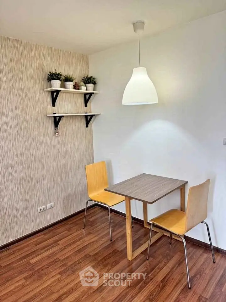 Cozy dining nook with modern chairs and pendant light in a stylish apartment.