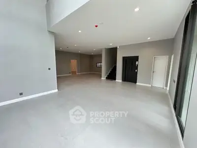 Spacious modern interior with high ceilings and sleek design, ideal for versatile living or office space.