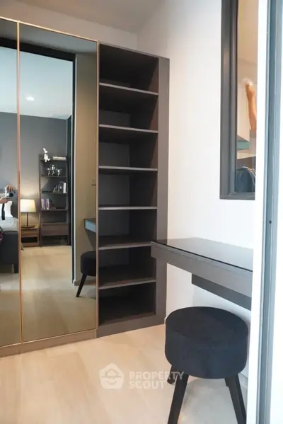 Modern bedroom with mirrored wardrobe and sleek study nook