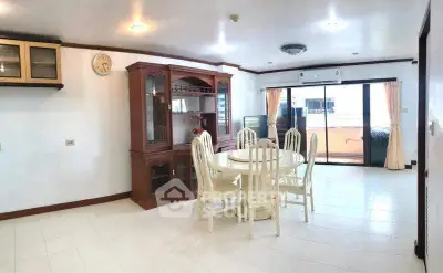 Spacious dining area with elegant wooden furniture and large windows for natural light.