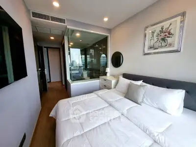 Modern bedroom with glass wall, cozy bedding, and stylish decor in a contemporary apartment.
