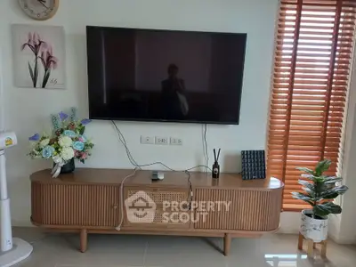 Modern living room with stylish TV stand and wall-mounted flat screen, accented by elegant decor and natural light.