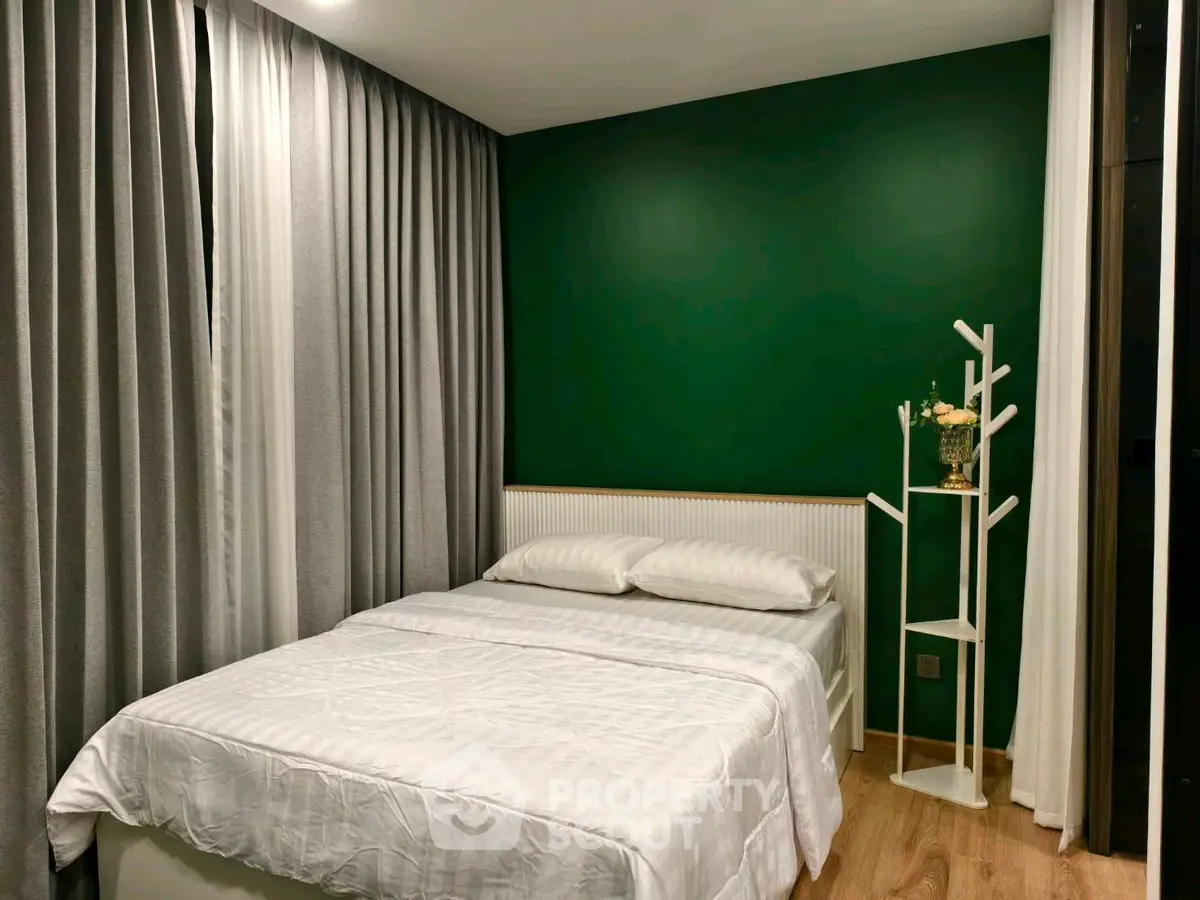 Cozy bedroom with green accent wall and modern decor