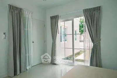 Bright bedroom with large windows and elegant curtains