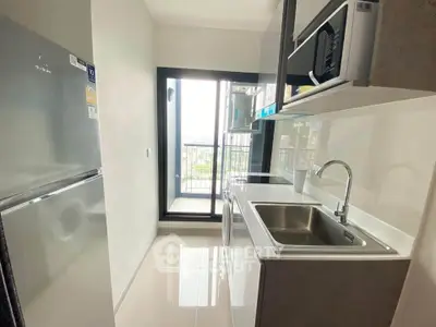 Modern kitchen with sleek appliances and balcony view in a stylish apartment.