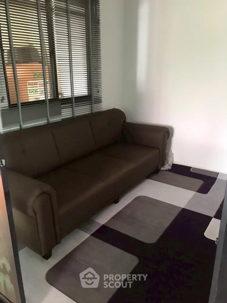 Cozy small living room with brown sofa and modern rug