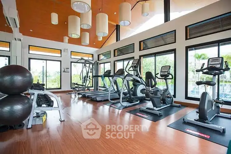 Spacious modern gym with large windows and state-of-the-art fitness equipment.