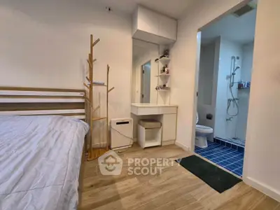 Modern bedroom with ensuite bathroom featuring sleek design and wooden flooring.