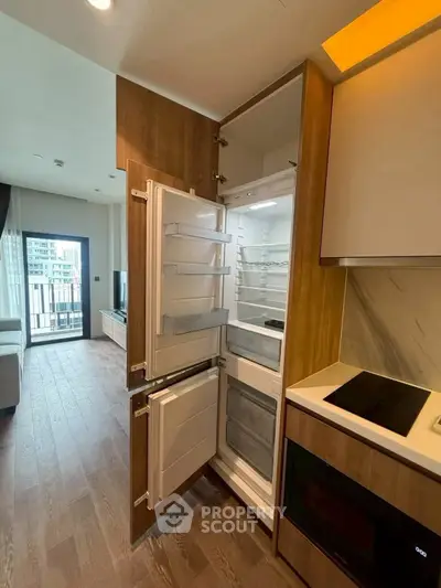 Modern kitchen with built-in fridge and open layout in stylish apartment