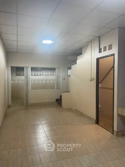 Spacious interior with tiled flooring and modern lighting, ideal for versatile living arrangements.