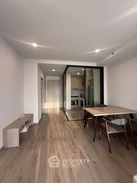 Modern living room with open kitchen and stylish dining area in a contemporary apartment.