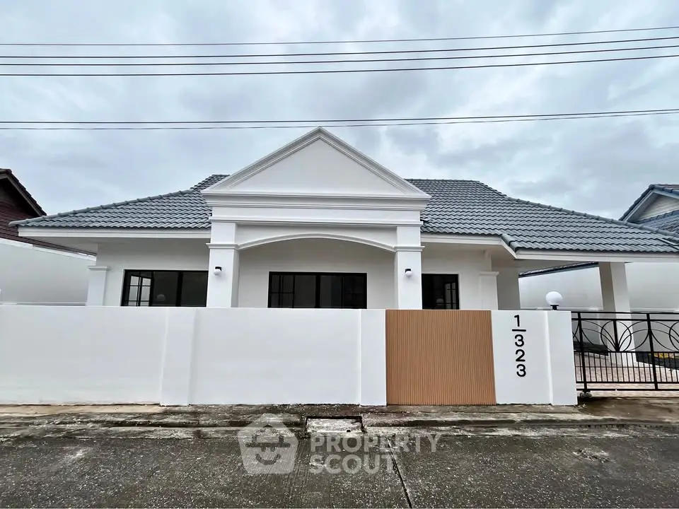 Charming single-story home with modern facade and gated entrance, perfect for family living.