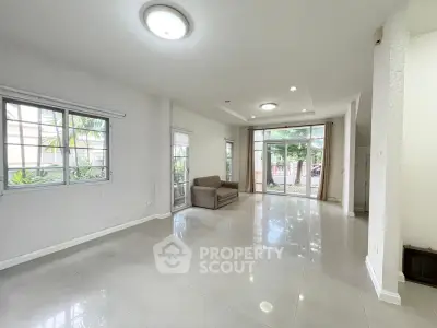 Spacious living room with large windows and garden view, perfect for family gatherings.
