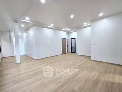 Spacious modern living room with sleek wooden flooring and recessed lighting