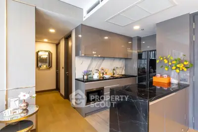 Modern kitchen with sleek cabinetry and marble island in luxury apartment.