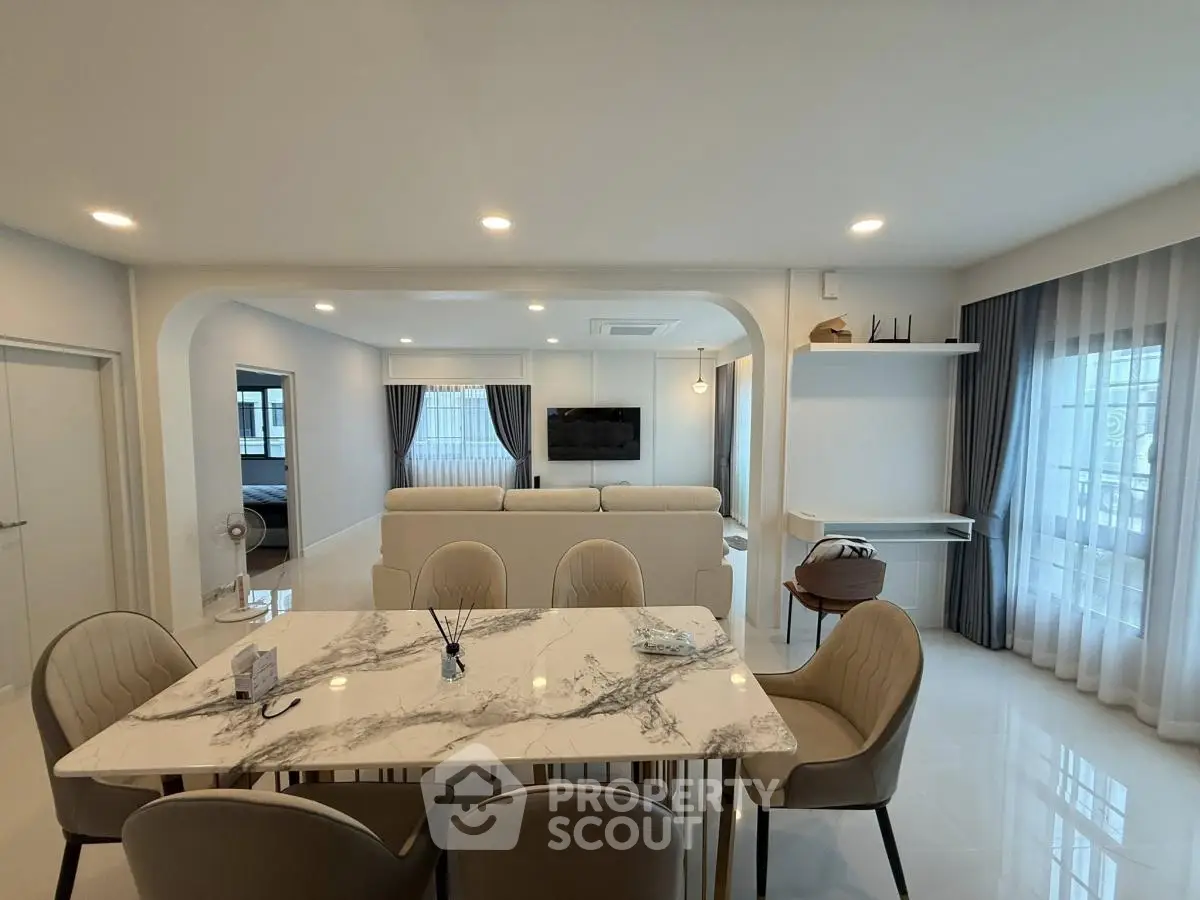 Elegant open-plan living and dining area with modern decor and ample natural light.