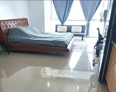 Spacious modern bedroom with sleek flooring and natural light, featuring a cozy bed and stylish decor.