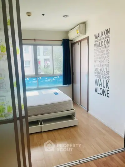 Bright bedroom with large window and modern decor in a stylish apartment.
