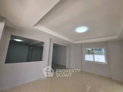 Spacious interior with modern ceiling design and tiled flooring, ideal for versatile living space.