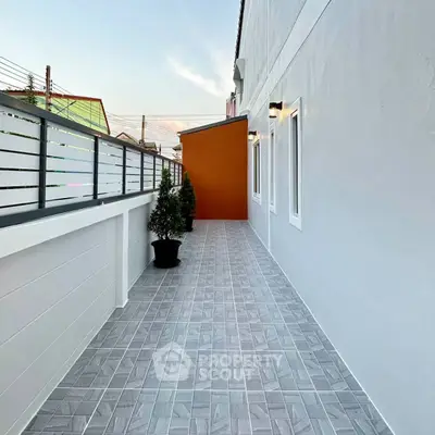Spacious modern balcony with stylish tiles and potted plants, perfect for relaxation.