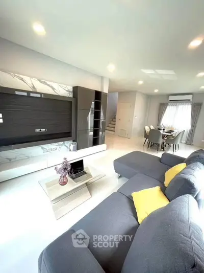 Spacious modern living room with stylish decor and open dining area, perfect for entertaining.