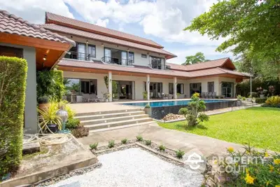 Luxurious two-story villa with pool and lush garden, perfect for serene living.