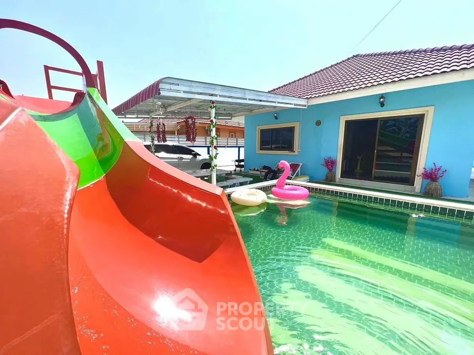 Vibrant poolside with colorful slide and inflatable toys at a modern home