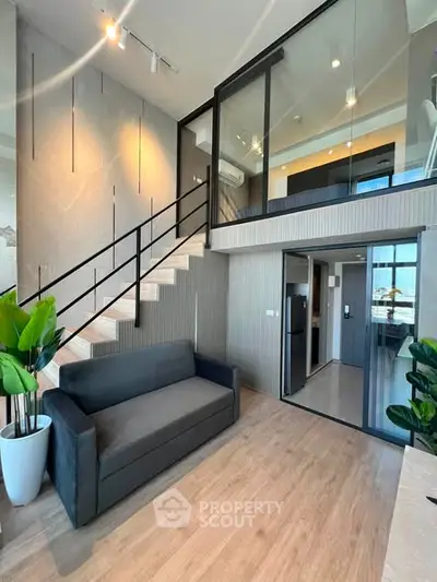 Modern duplex apartment with stylish interior, featuring a cozy living area and sleek staircase design.