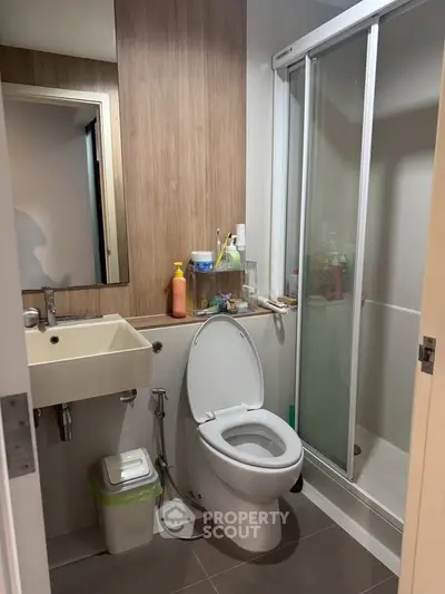 Modern bathroom with sleek design, featuring a glass shower and contemporary fixtures.